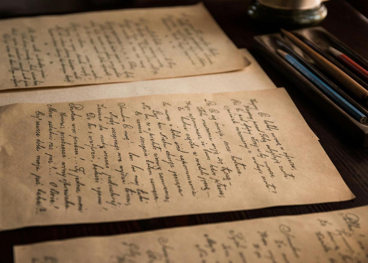 Multiple handwritten letters on old paper stacked on a desk