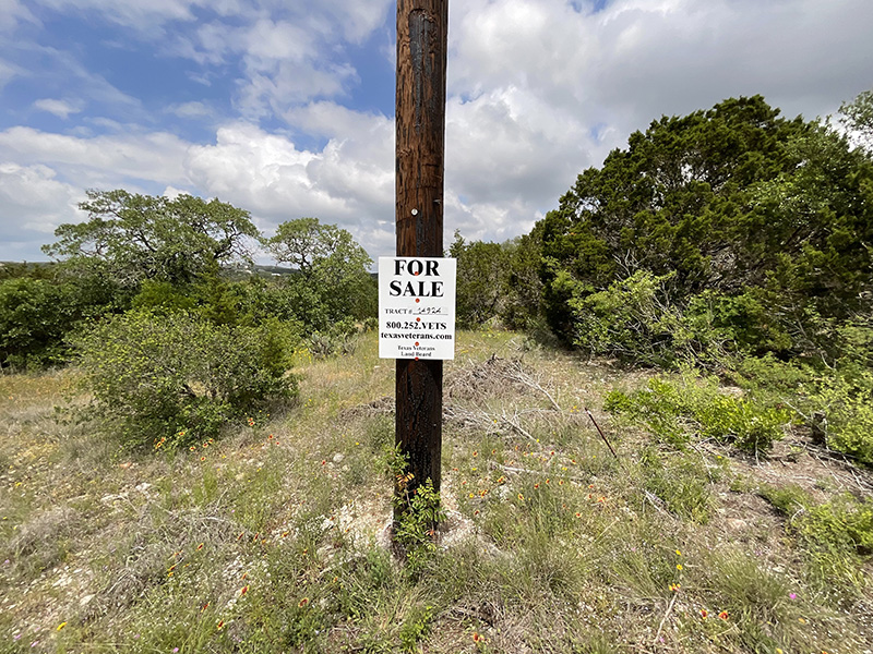 A for sale sign on a utility pole in the Texas Hill Country.