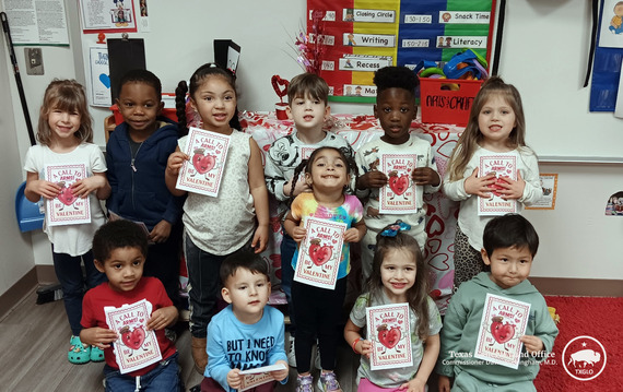 Kids holding up Valentines Day cards