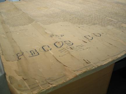 Bottom left corner of an original map with tattered edges with Pecos Co written in a vintage font